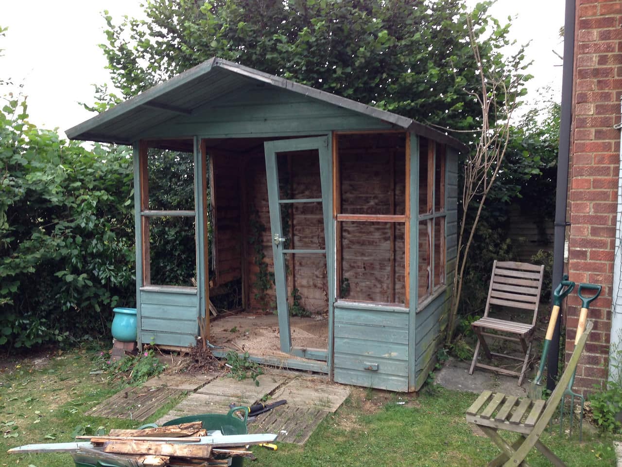 A rotten wooden summerhouse, in the midst of being demolished